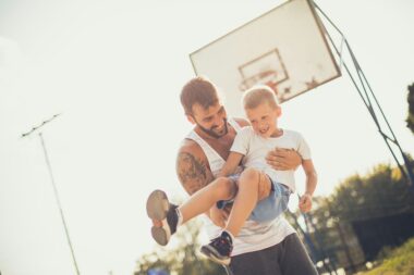 Father and child playing in a park, showcasing the joys of fatherhood.