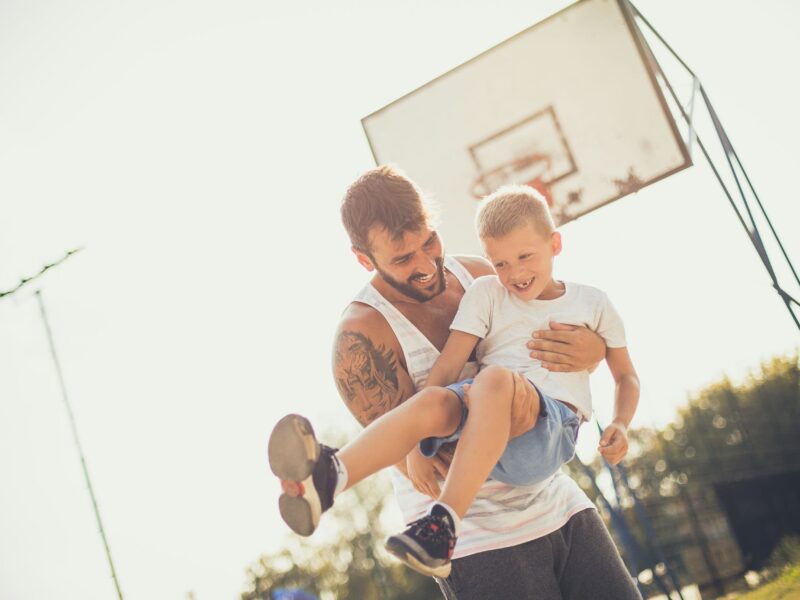 Father and child playing in a park, showcasing the joys of fatherhood.