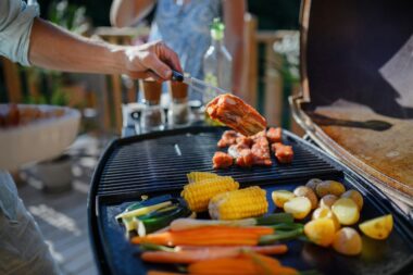 Close-up of a summer BBQ grill with assorted meats and vegetables.