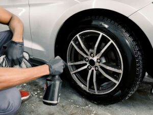 Person performing routine car maintenance check to ensure vehicle is in top condition.