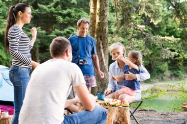 Middle-aged man enjoying quality time with his family outdoors, strengthening their relationships through meaningful activities.