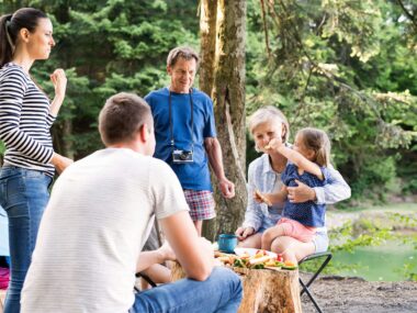 Middle-aged man enjoying quality time with his family outdoors, strengthening their relationships through meaningful activities.