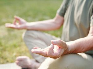 Practicing mindfulness meditation in nature to reduce stress and enhance mental well-being.