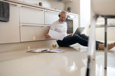 Middle-aged man with must-have tech gadgets for 2024, including a smartwatch, smart home device, and smartphone.