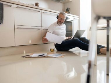 Middle-aged man with must-have tech gadgets for 2024, including a smartwatch, smart home device, and smartphone.