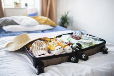 Efficiently packed suitcase with rolled clothes and packing cubes.